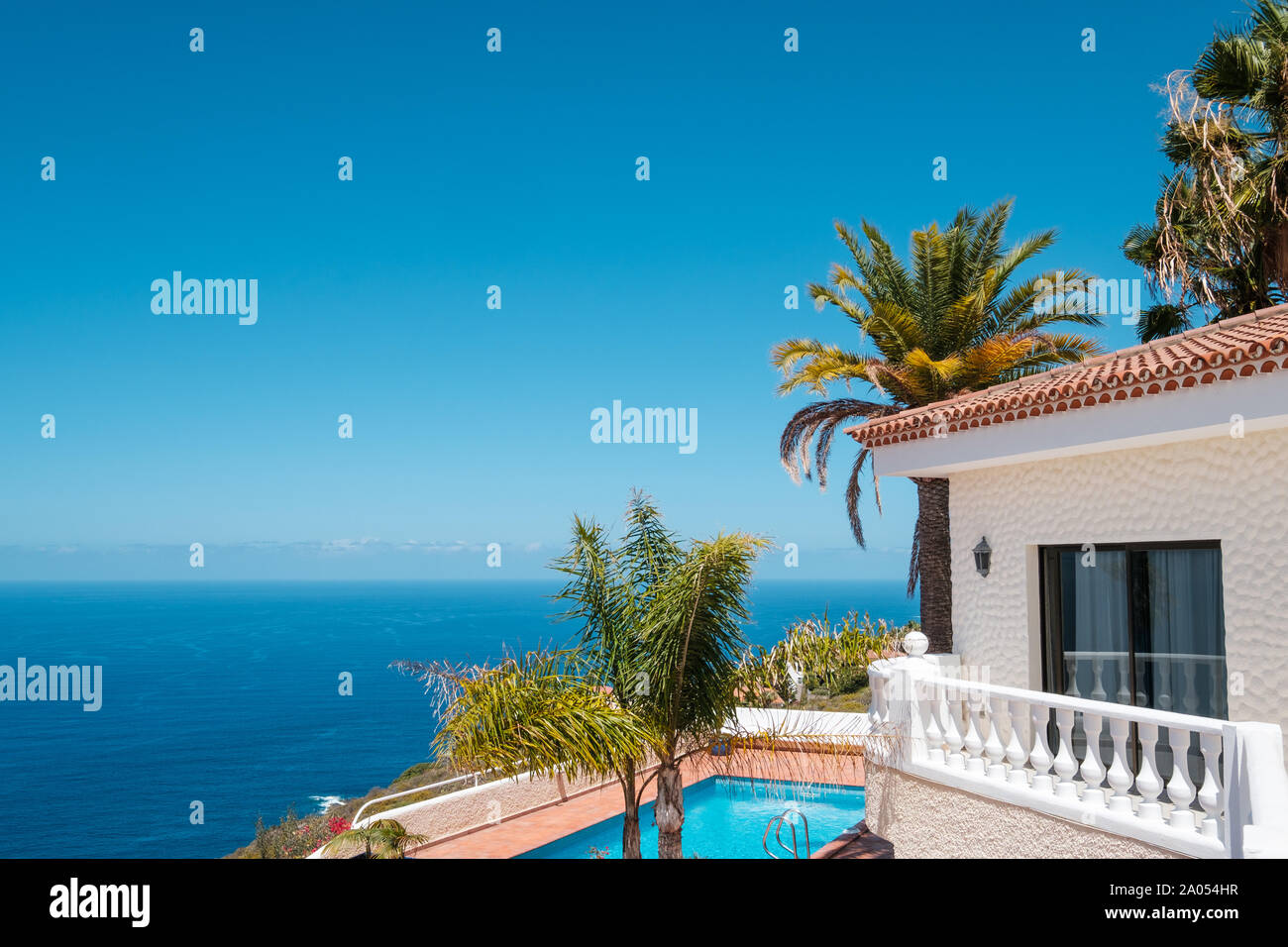 Casa con piscina, palmeras y del mar vista al mar Foto de stock