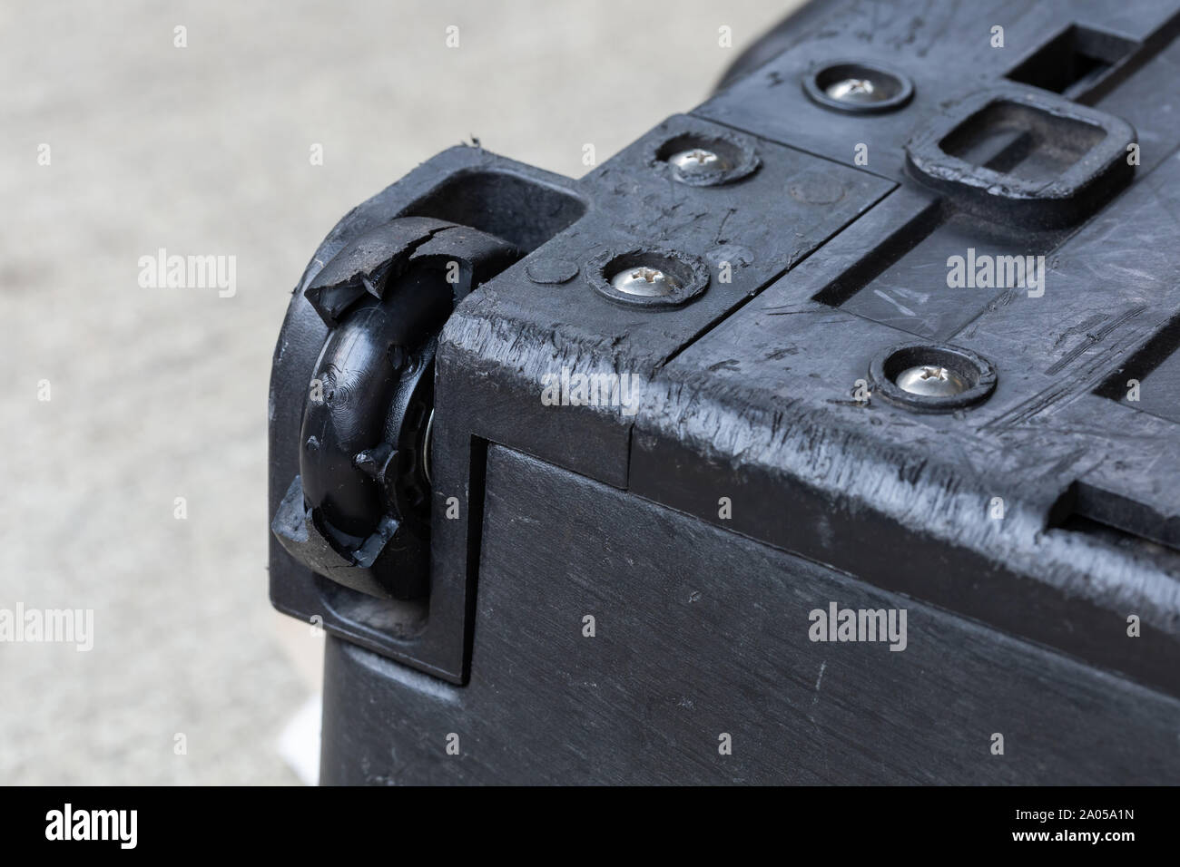 Cerrar agrietado roto dañado caducado arruinado desgarrado cojinete de  caucho caja rígida maleta equipaje necesario sustituir la rueda para reparar  o arreglar el problema Fotografía de stock - Alamy