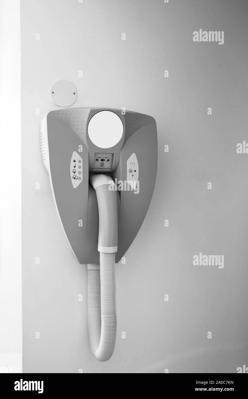 Imagen en blanco y negro de secador colgado en la pared del cuarto de baño en un hotel moderno con enchufe para la máquina de afeitar - imagen en blanco y negro. Foto de stock