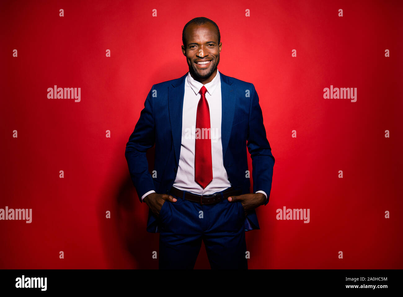 Foto de buena atractiva alegre guapo jefe chic elegante hombre que confía en el moderno tux Smoking azul profundo formal mantiene las manos en los bolsillos es Fotografía de stock -