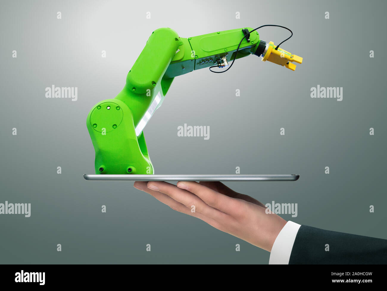 Hombre sujetando una tableta digital con robot de manipulación con brazo robótico. Foto de stock