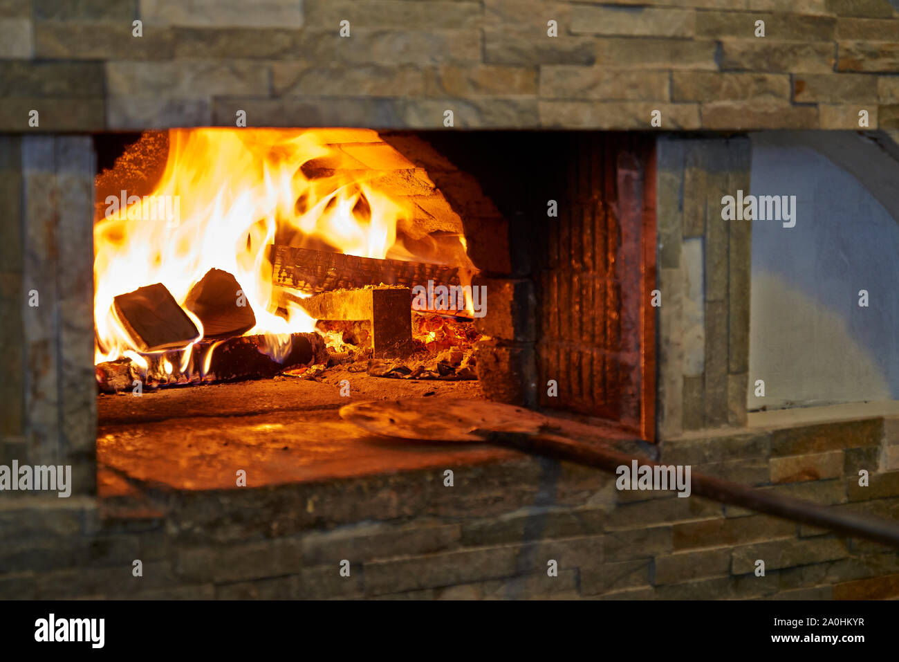 Pizzería La estufa de madera con una llama y branding Foto de stock