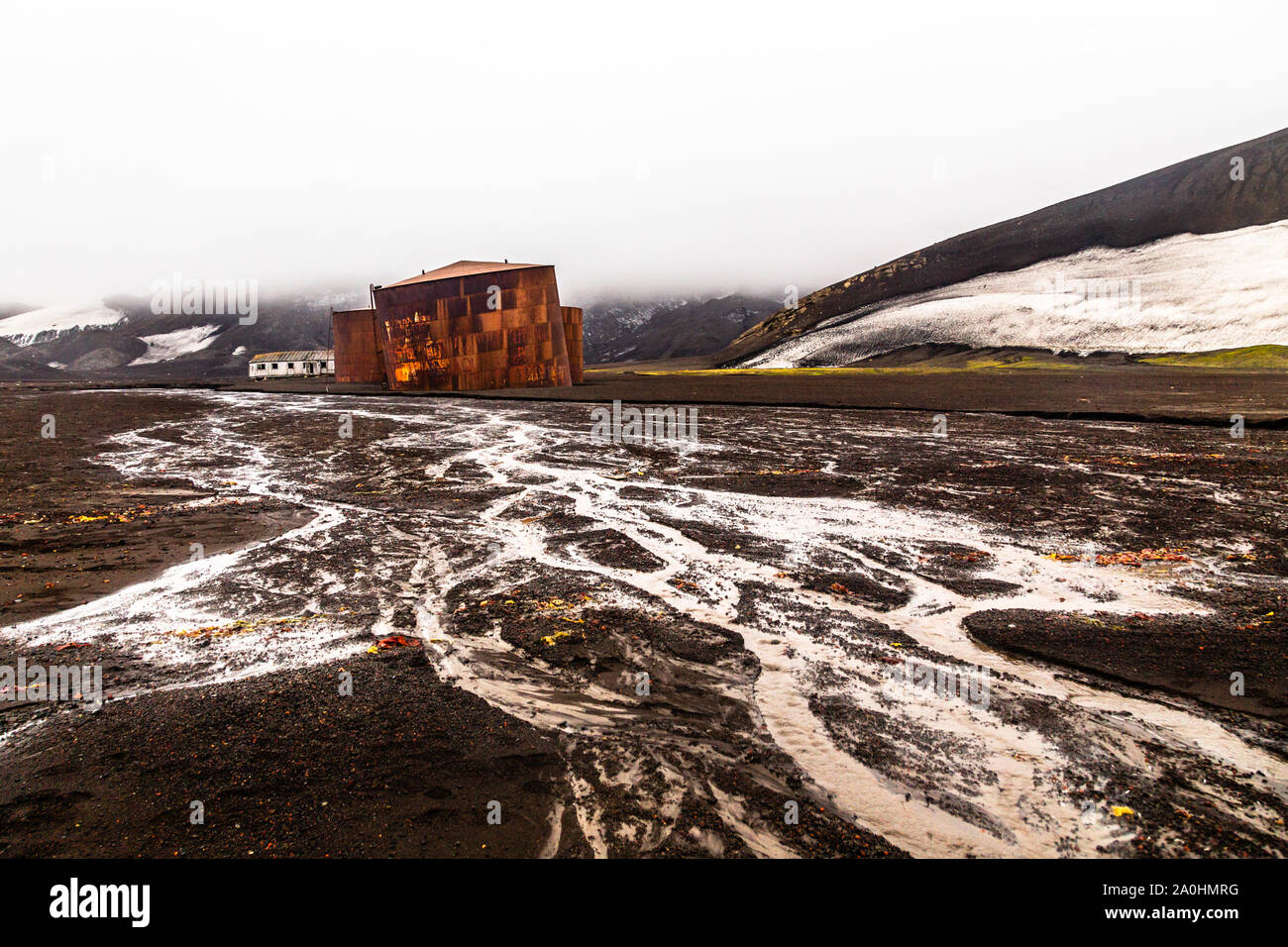Abandonada estación de cazadores de ballenas de Noruega rusty grasa tanques con lodoso río en primer plano en la Isla Decepción, Antártida Foto de stock