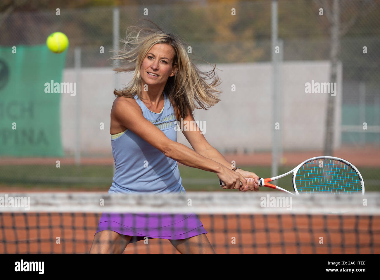 Mujer jugando al tenis golpeando un disparo de revés Foto de stock