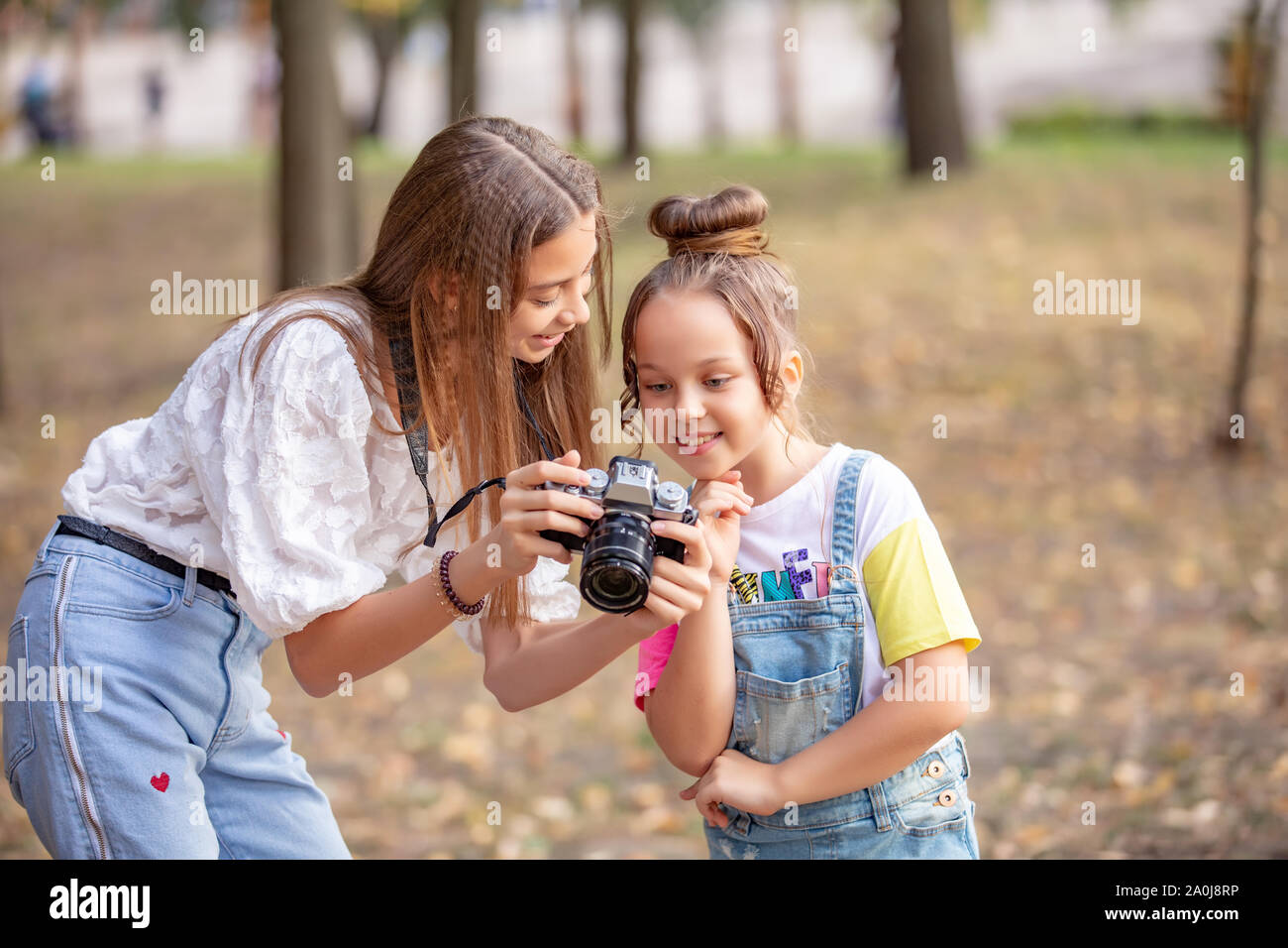 Dos niñas de la calle, hacer un para Internet, grabar un vídeo blog para la cámara. Los niños con foto appart en un parque de la ciudad de dos hermanas Fotografía