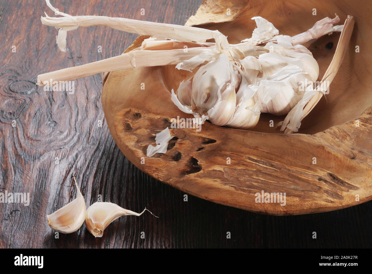 Bulbo de ajo fresco y dientes de ajo sobre la mesa de madera Foto de stock