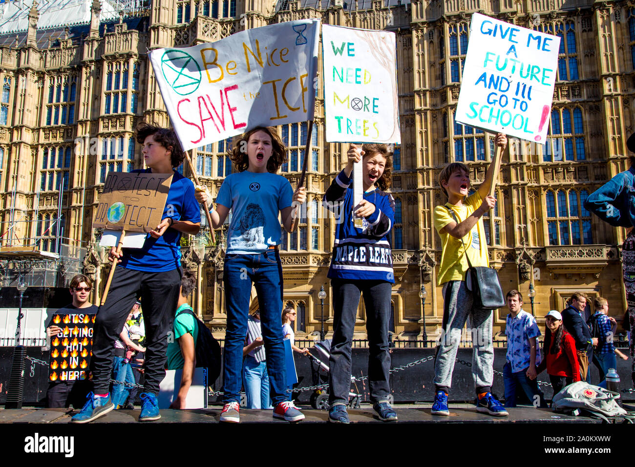 El 20 de septiembre de 2019, Londres, Reino Unido - Escolares de pie sobre una pared con pancartas, gritando consignas en el Clima Global Strike en Westminster. Foto de stock