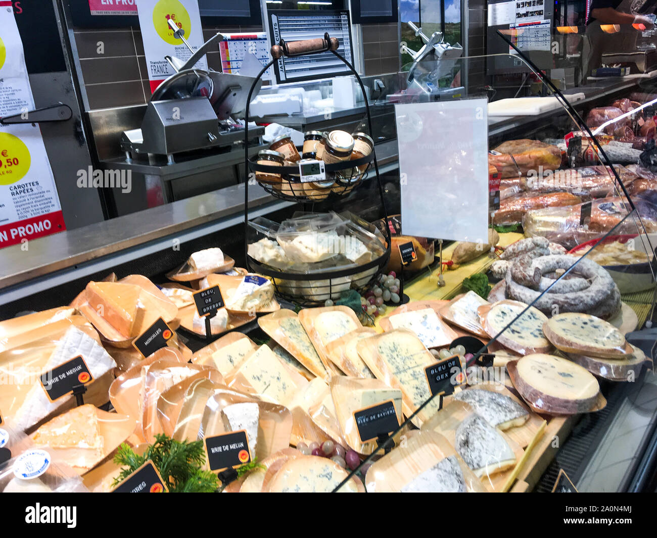 Quesos y carnes de cerdo muestran en un estante refrigerado, Supermercado, Lyon, Francia. Foto de stock