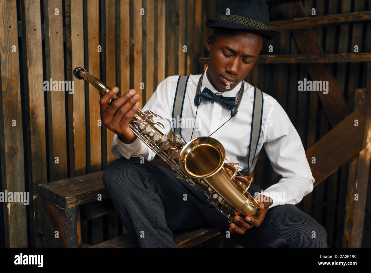 Músico de jazz negro sentado con el saxofón Foto de stock