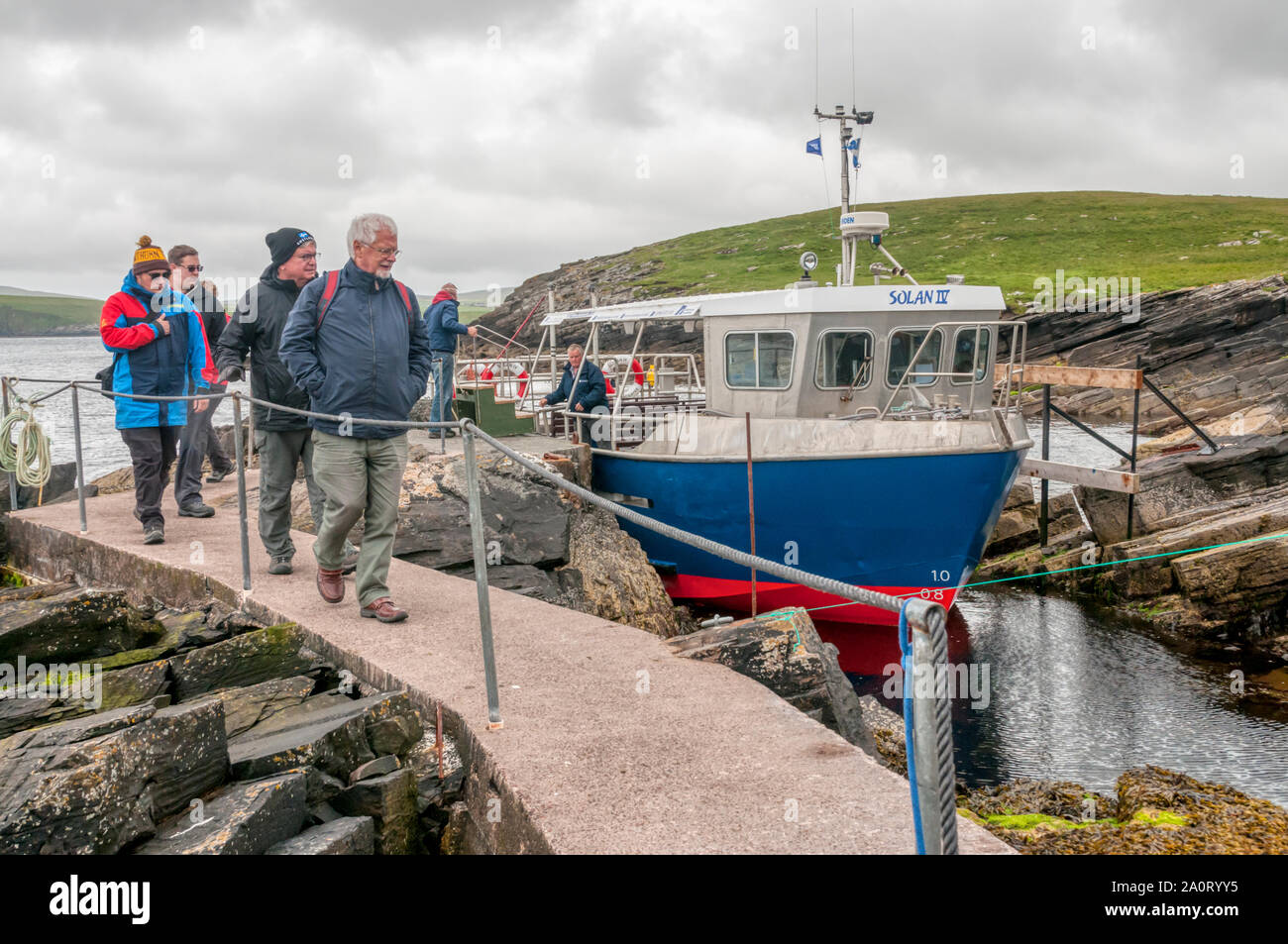Las personas que llegan a la isla de Mousa de desembarque del barco Mousa Shetland ferry desde el continente. Foto de stock