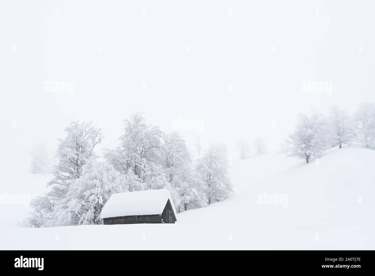 País de las maravillas invernal con una casa de madera en las montañas. Snowy Navidad en un pueblo de montaña. Colinas y árboles en la nieve. Foto de stock