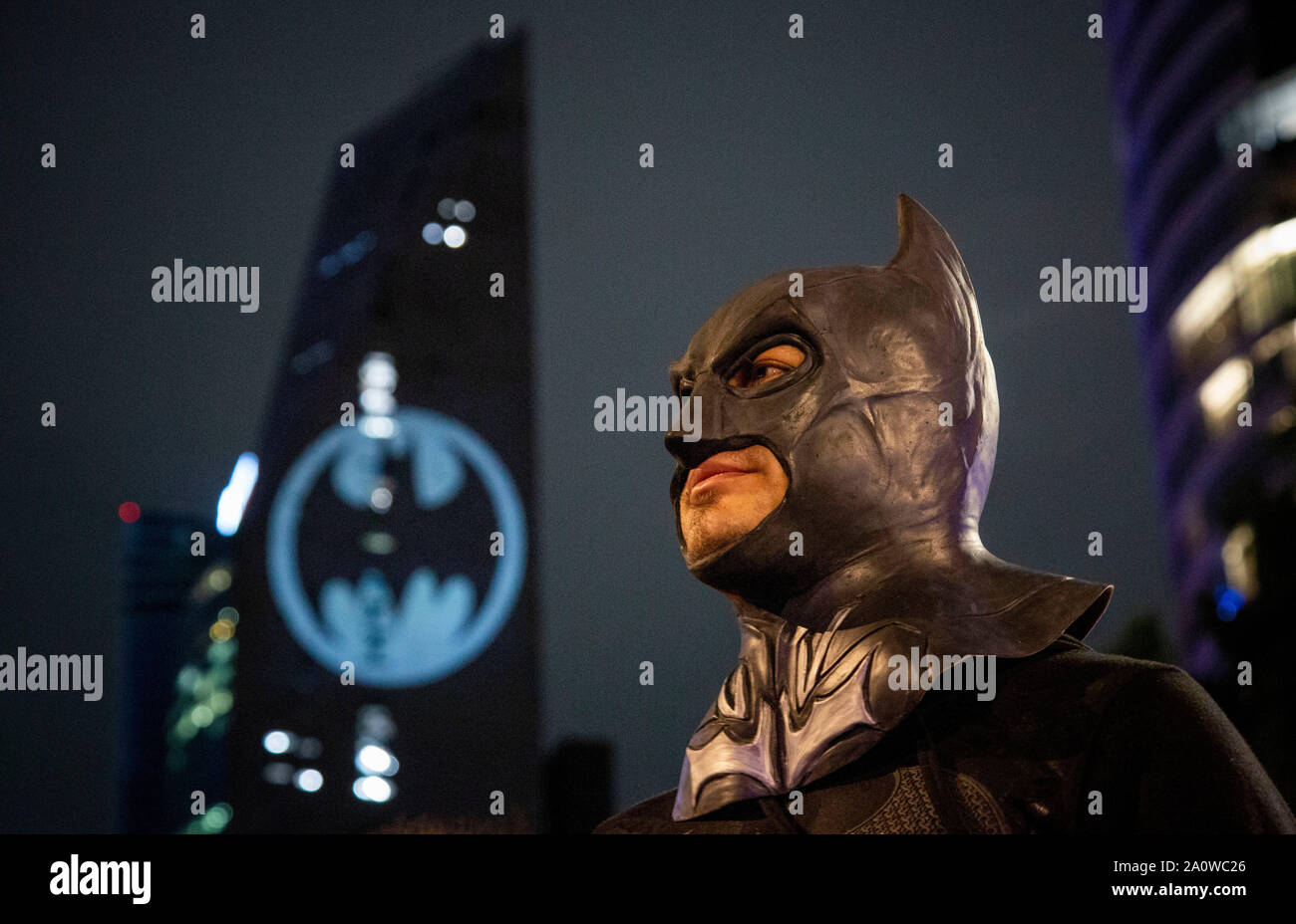 Mexiko Stadt, México. 21 Sep, 2019. Un hombre vestido como Batman se sitúa  delante de un edificio que se ilumina con un sello de Batman. El sábado,  los fanáticos de Batman celebró
