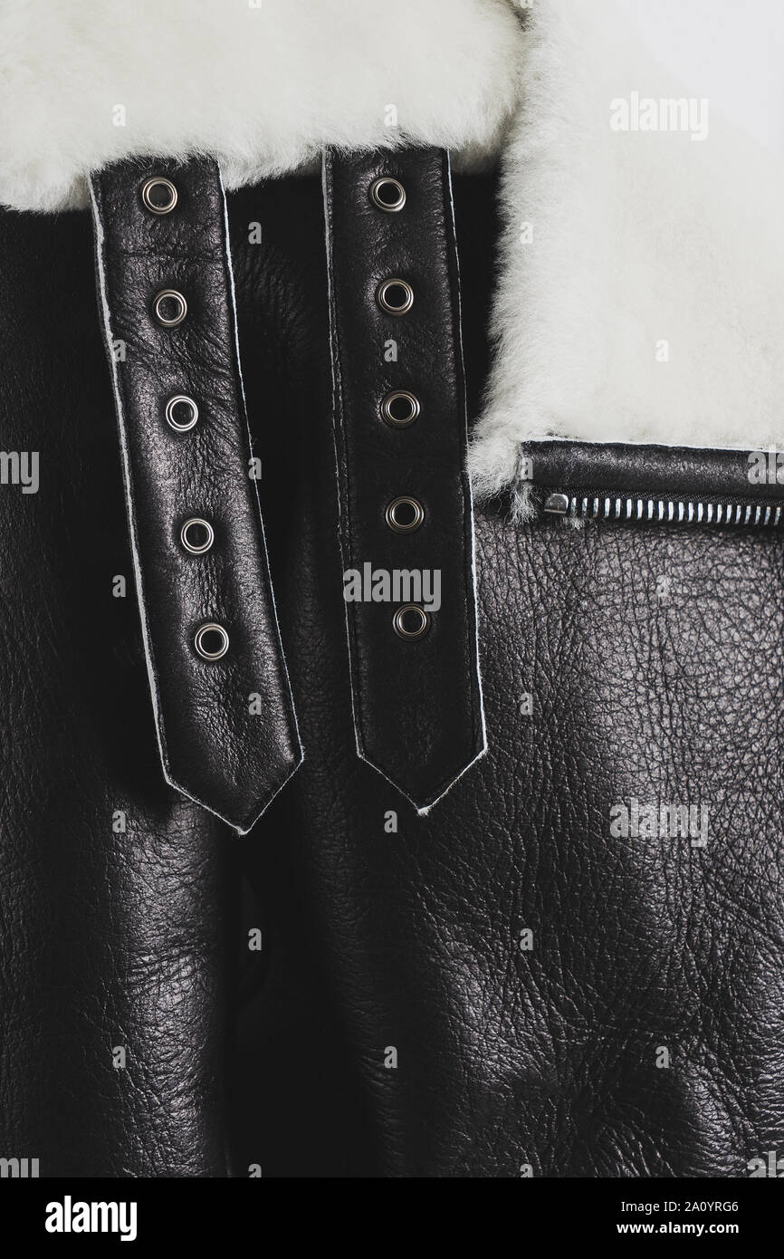 Parte de un abrigo de oveja negra de cuero con pelo y cinturones con  corbata. Closeup material texturado Fotografía de stock - Alamy