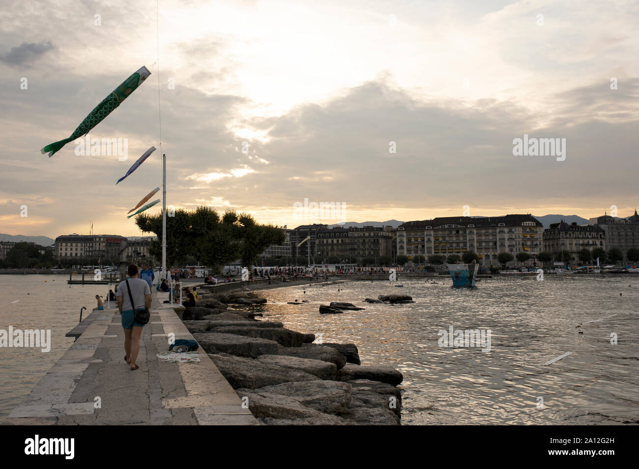 Atardecer en los Bains des Pâquis atrae visitantes veraniegos al Quai du Mont-Blanc en Lago Leman (Lago de Ginebra), en Ginebra, Suiza. Foto de stock