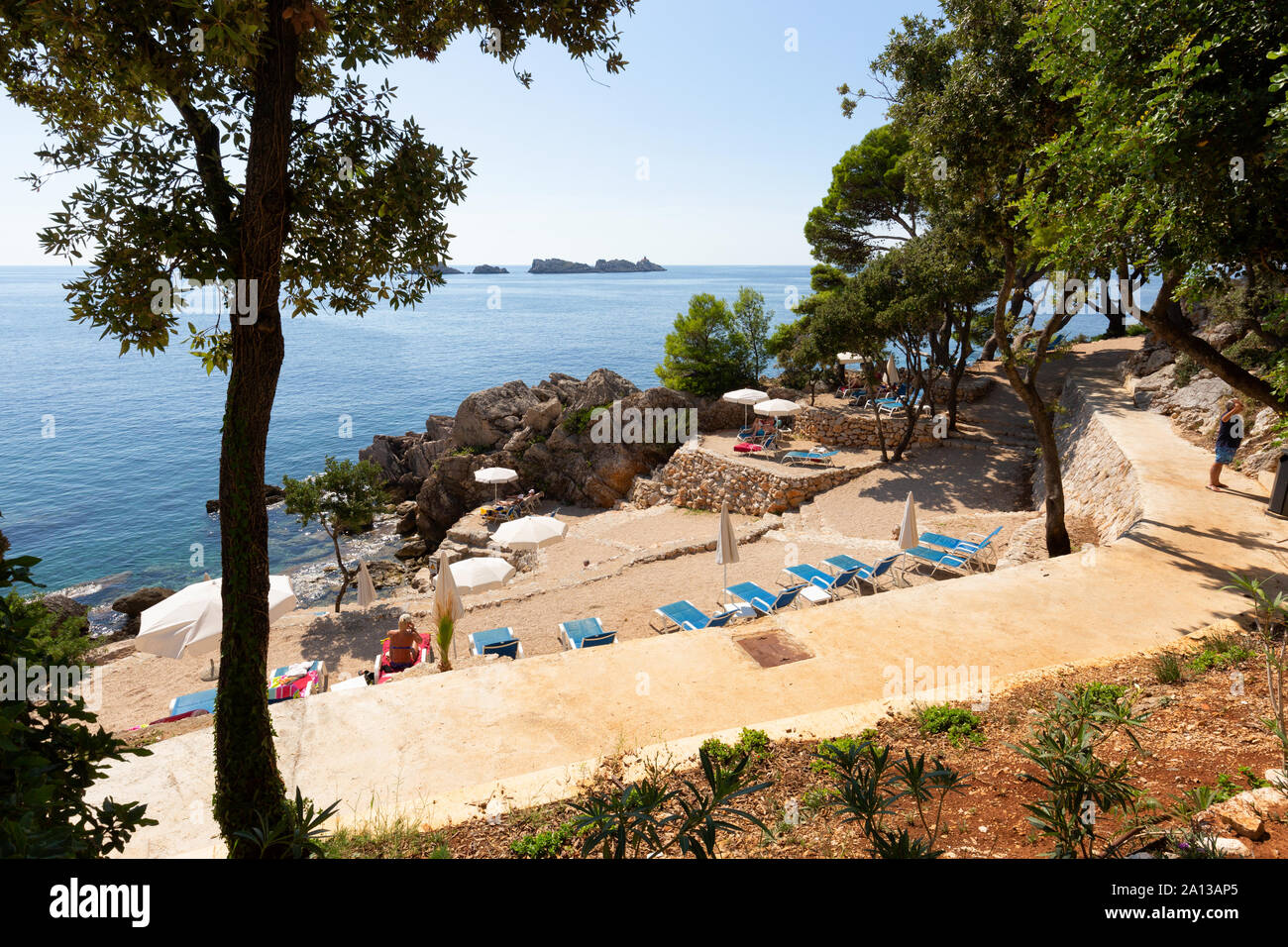 Costa dálmata - gente tomando sol en vacaciones en la rocosa costa croata cerca de Dubrovnik, Croacia, Europa Foto de stock