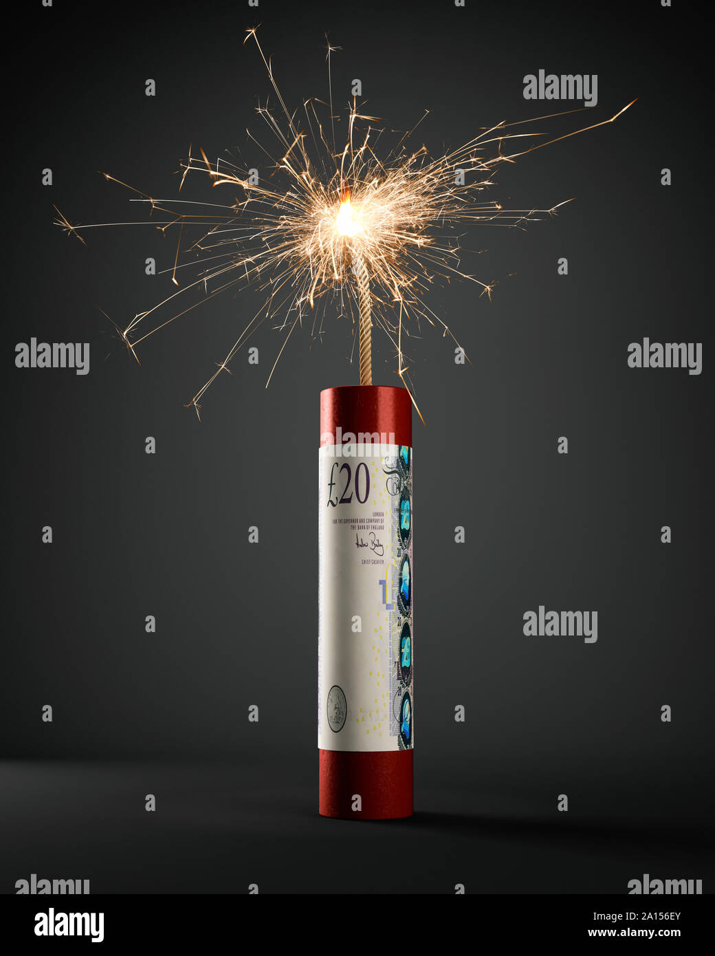 Cartucho de dinamita con nota de 20 libras esterlinas GBP, iluminadas y quemando Foto de stock