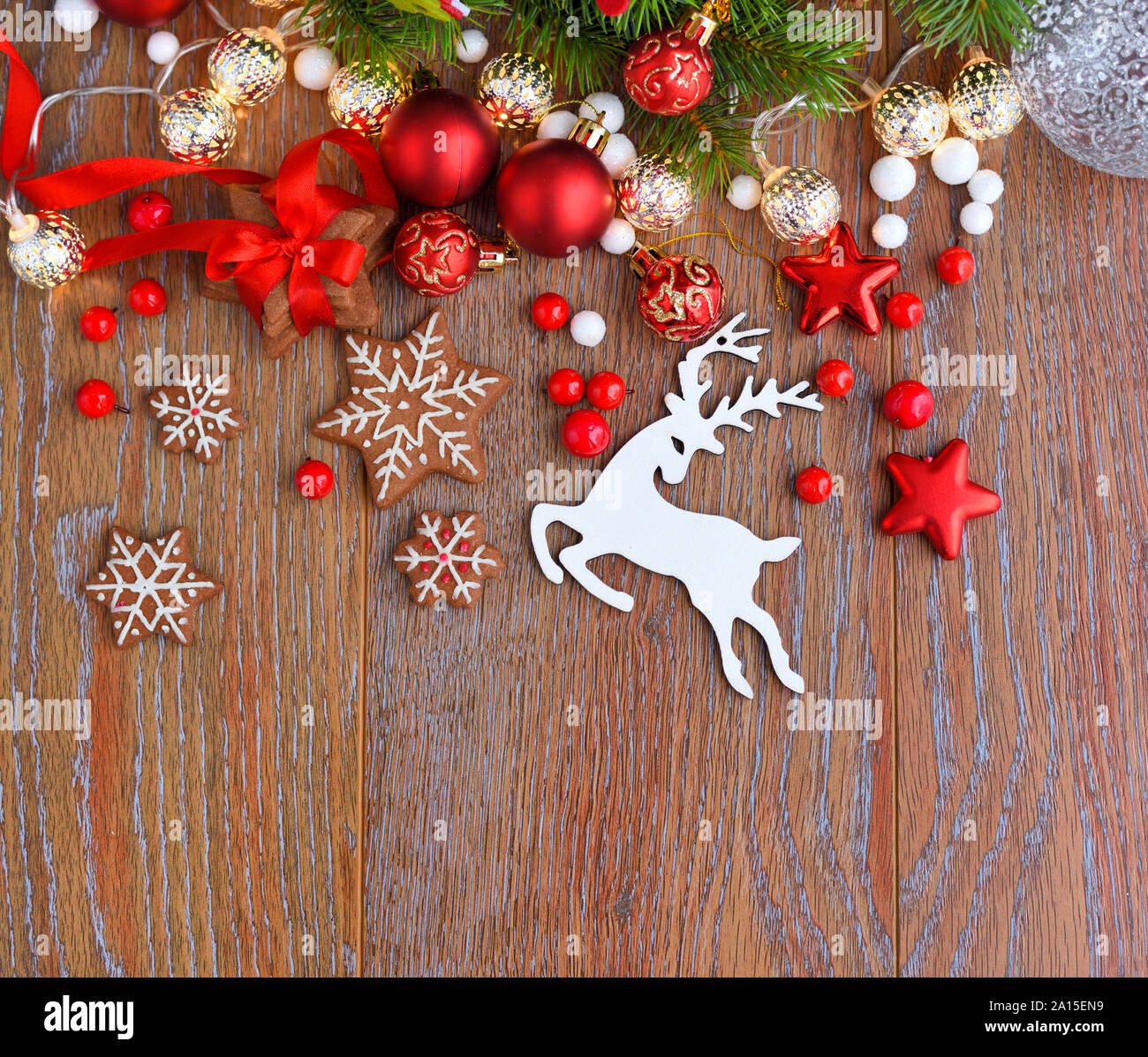 Galletas de Navidad con decoraciones festivas y ramas de abeto en una mesa de madera. Antecedentes festiva. Vista superior, espacio de copia. Foto de stock