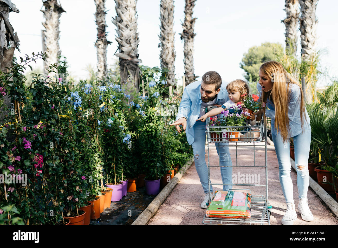 Sorprendido familia comprar plantas en un centro de jardinería con la hija en compras Foto de stock