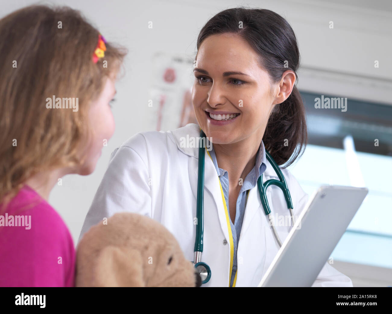 Doctora mostrando un paciente joven sus resultados de laboratorio en una tableta digital en la clínica Foto de stock