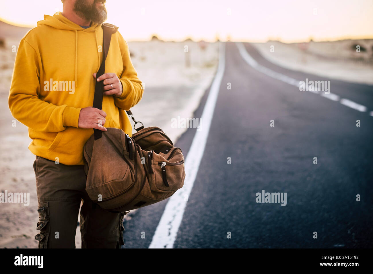 Hombre con sudadera con capucha de color amarillo y marrón en una calle de  la cesta Fotografía de stock - Alamy