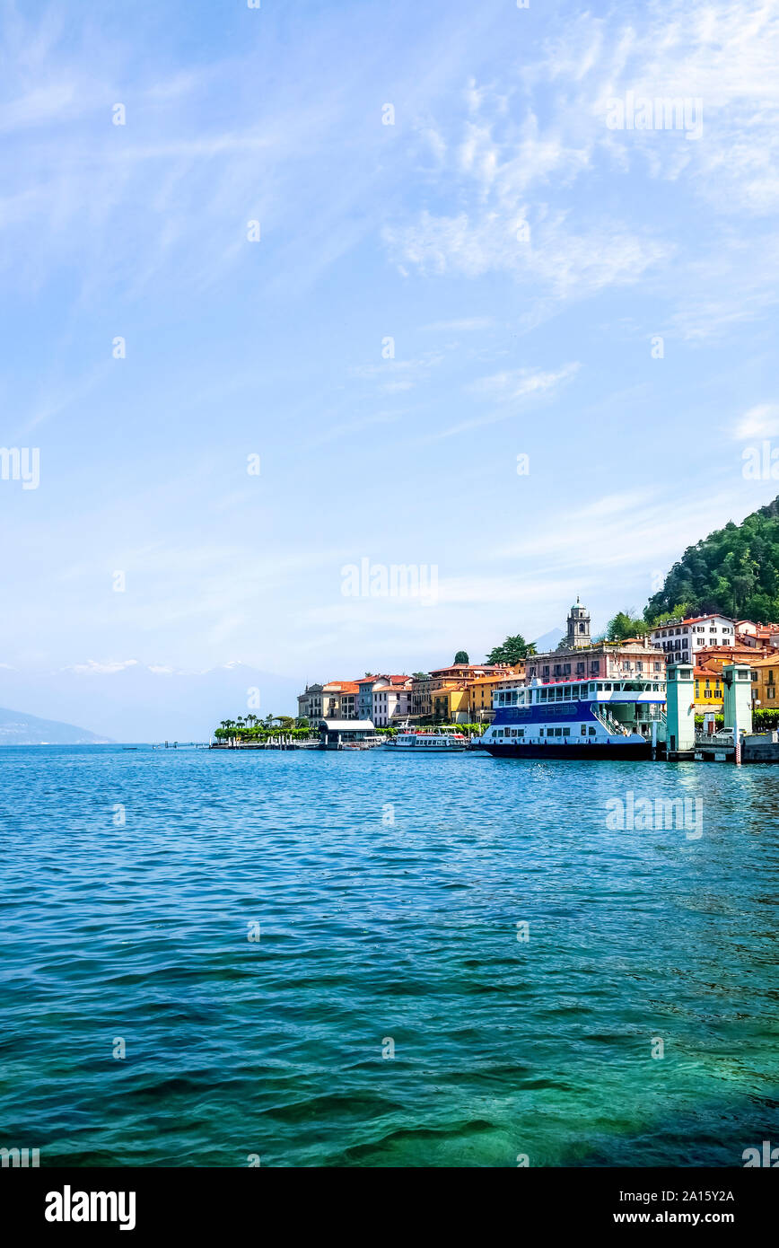 Ferry barco anclado en el Lago de Como contra el cielo azul Foto de stock