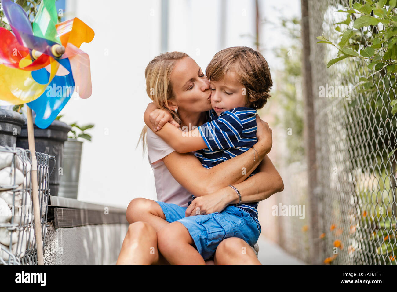 Madre Hijo snd abrazos y besos en el jardín Foto de stock