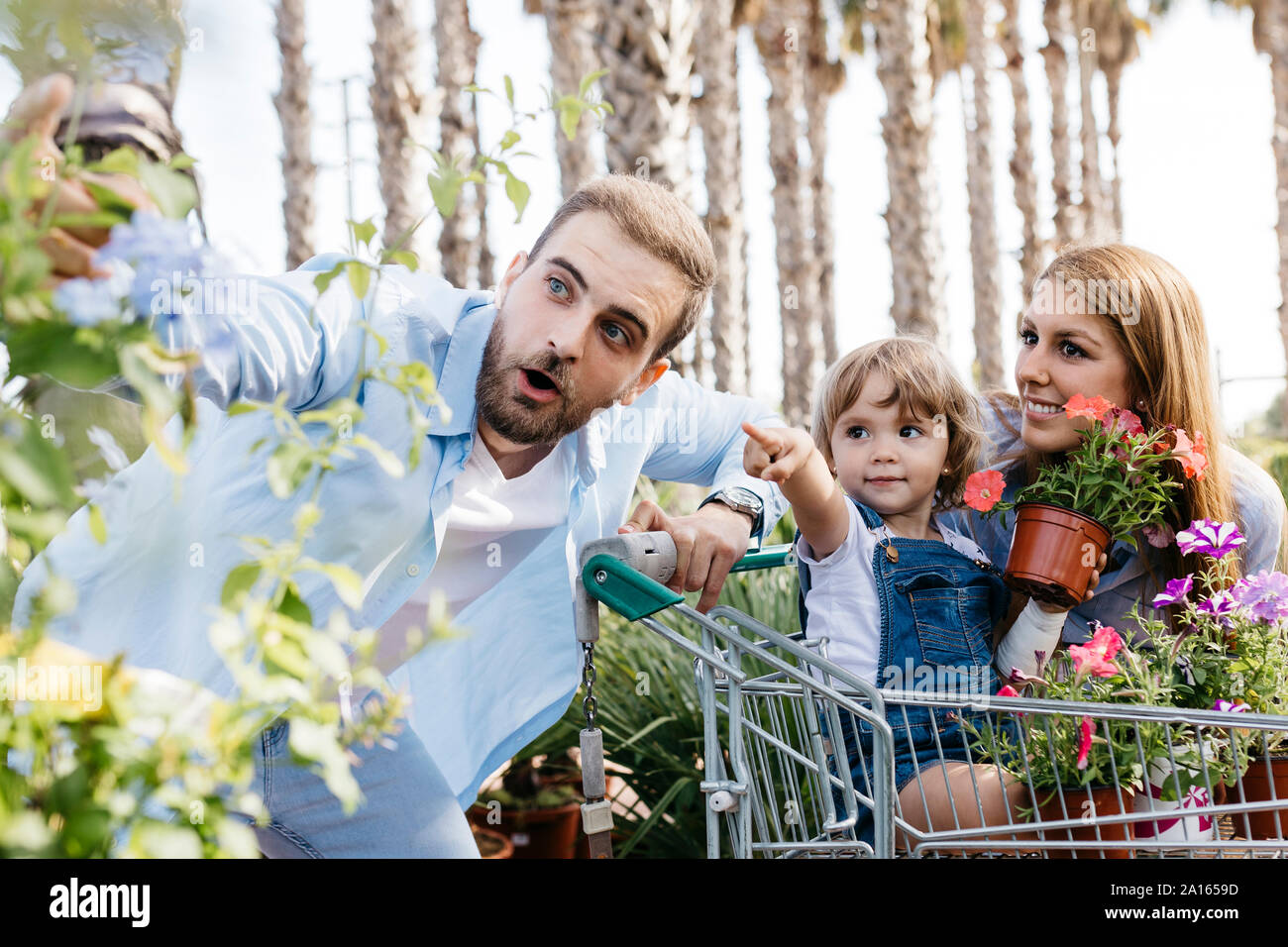Familia comprar plantas en un centro de jardinería con la hija en compras Foto de stock