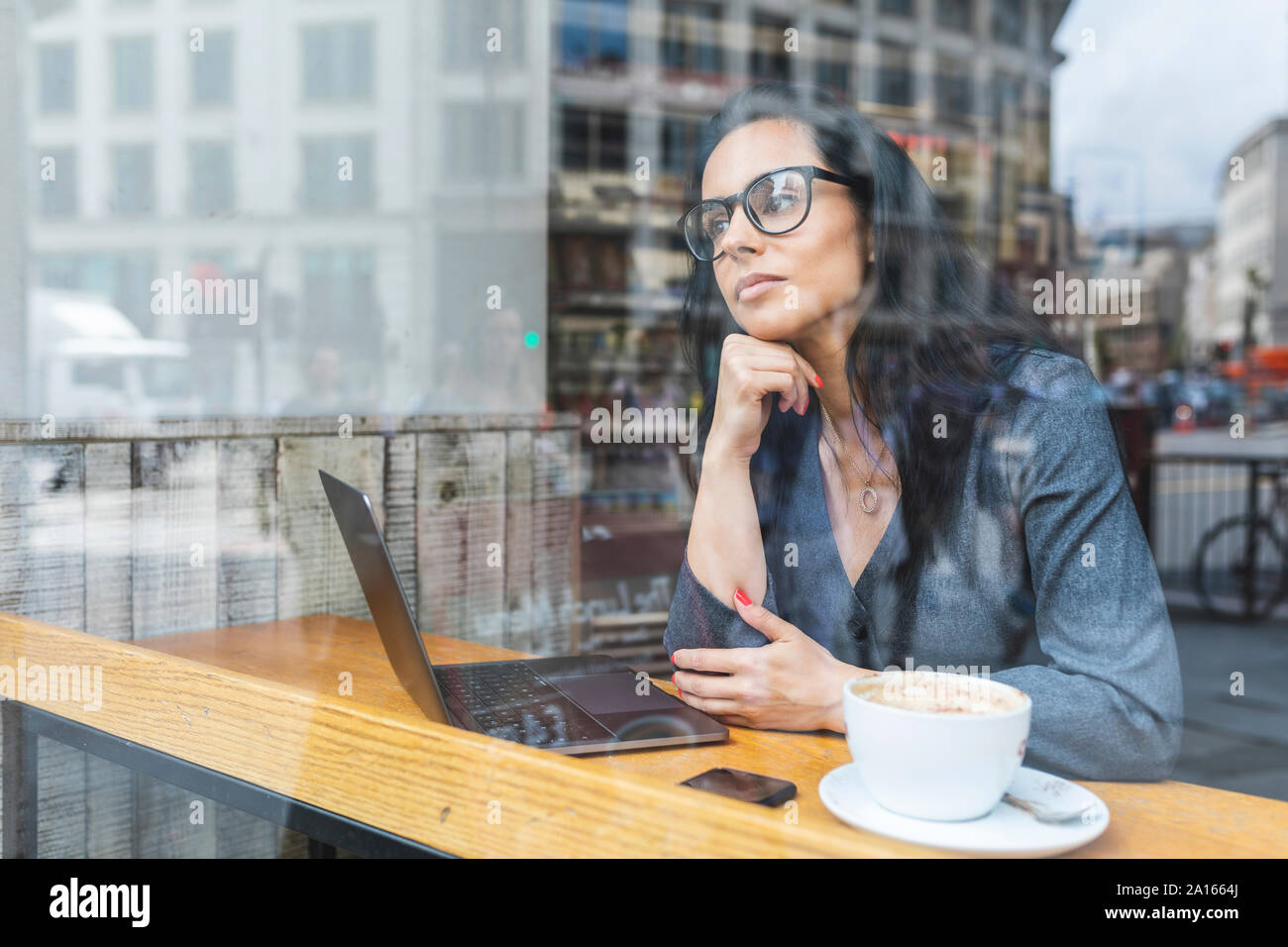 Mujer de negocios tener un descanso en una cafetería y trabajando con un portátil Foto de stock