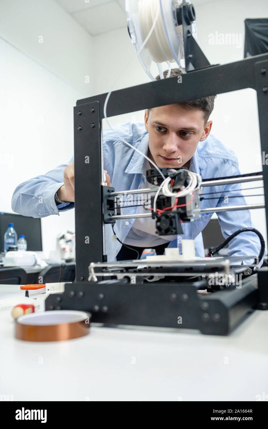 Estudiante configurar impresora 3D, utilización portátil Fotografía de  stock - Alamy
