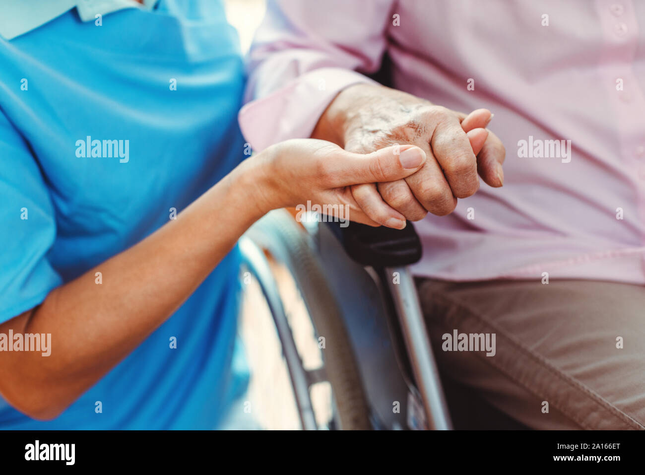 Enfermera consolador de una mujer mayor en el hogar de ancianos sosteniendo su mano en el hogar de ancianos Foto de stock