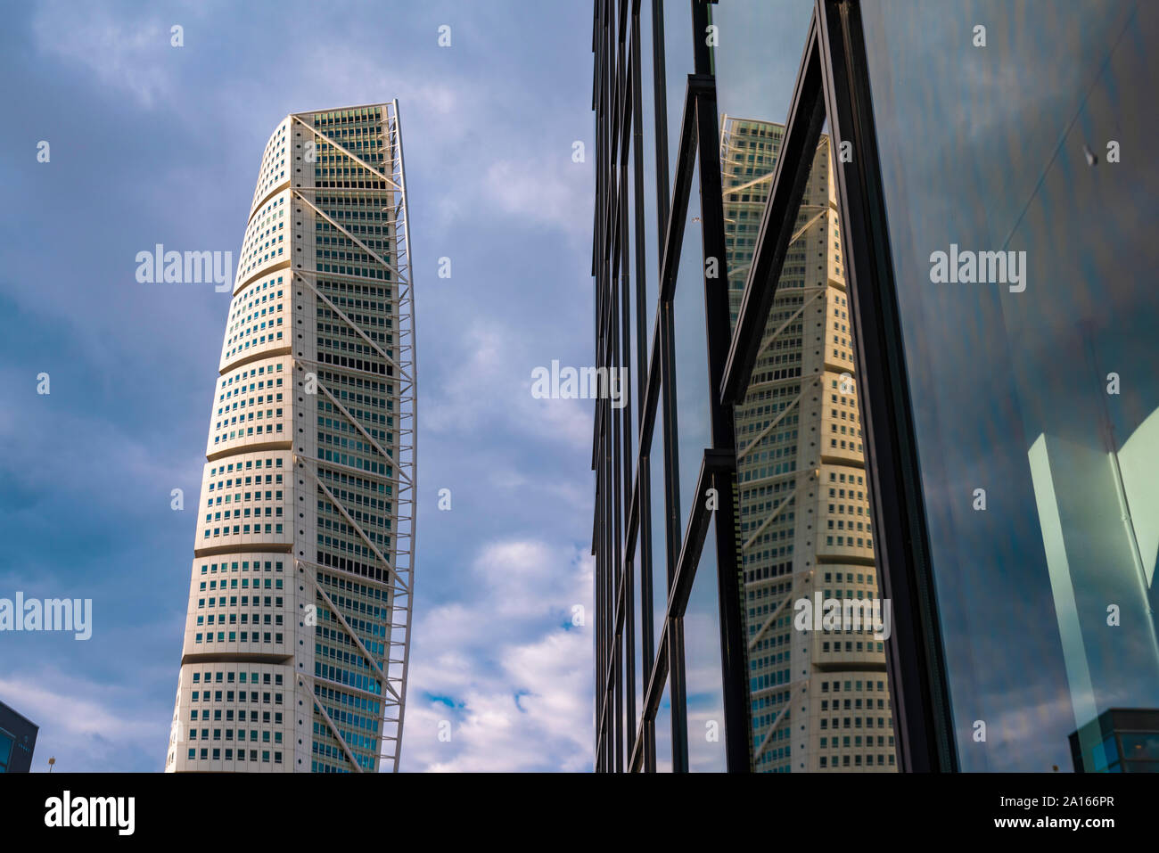 Ángulo de visión baja de Turning Torso Tower y moderno edificio contra el cielo Foto de stock