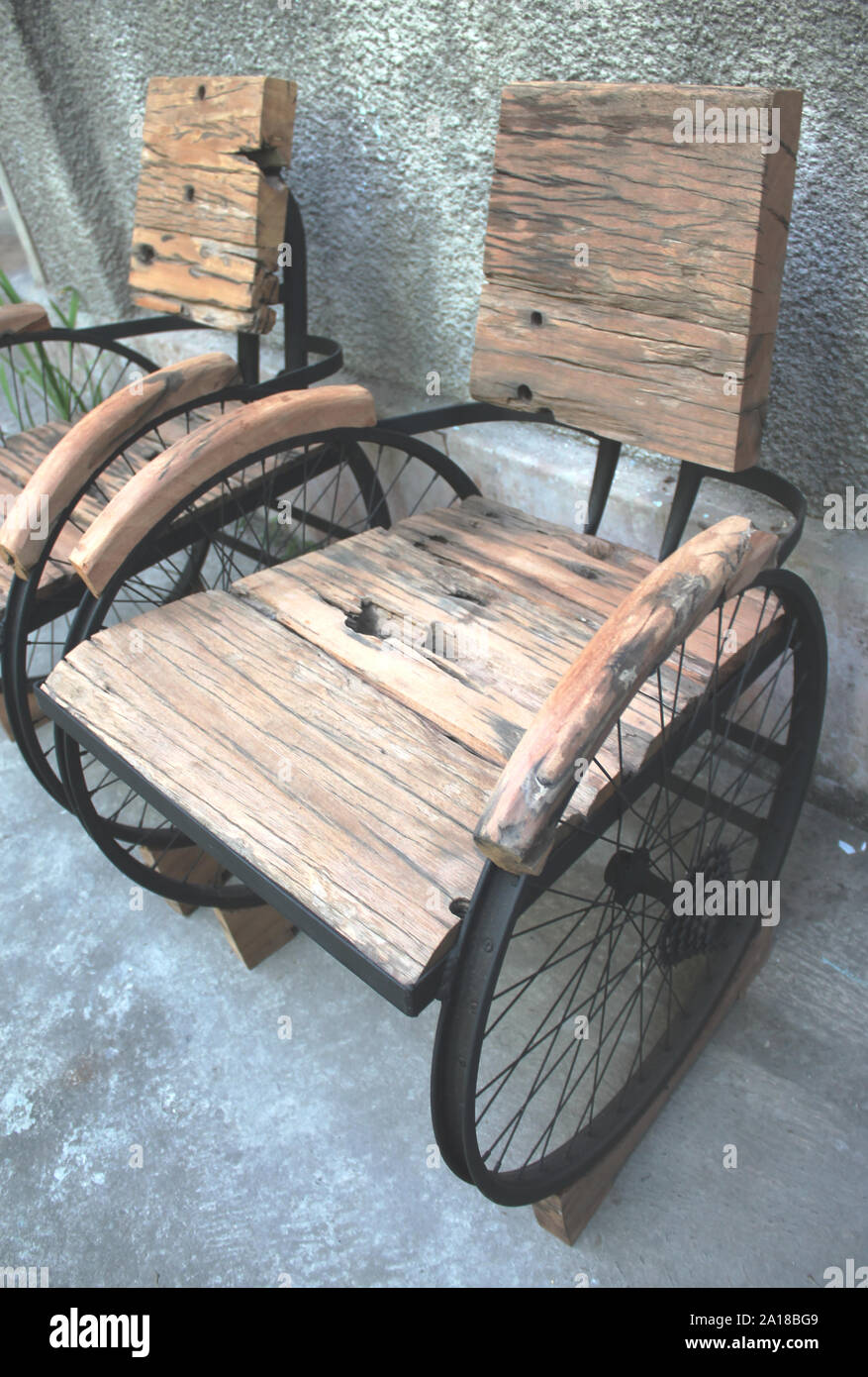 Una combinación de muebles antiguos de madera y sillas de hierro hechas de bienes usados Foto de stock