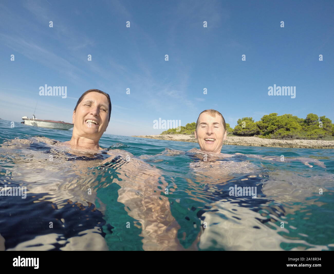 Dos mujeres nadando en el azul claro del mar Adriático Foto de stock