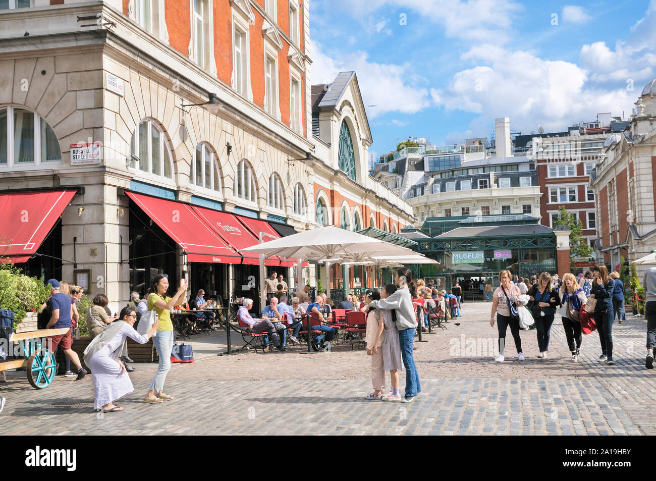 Los turistas disfrutando del verano en la plaza de Covent Garden en el West End de Londres, Londres, Inglaterra, Reino Unido. Foto de stock