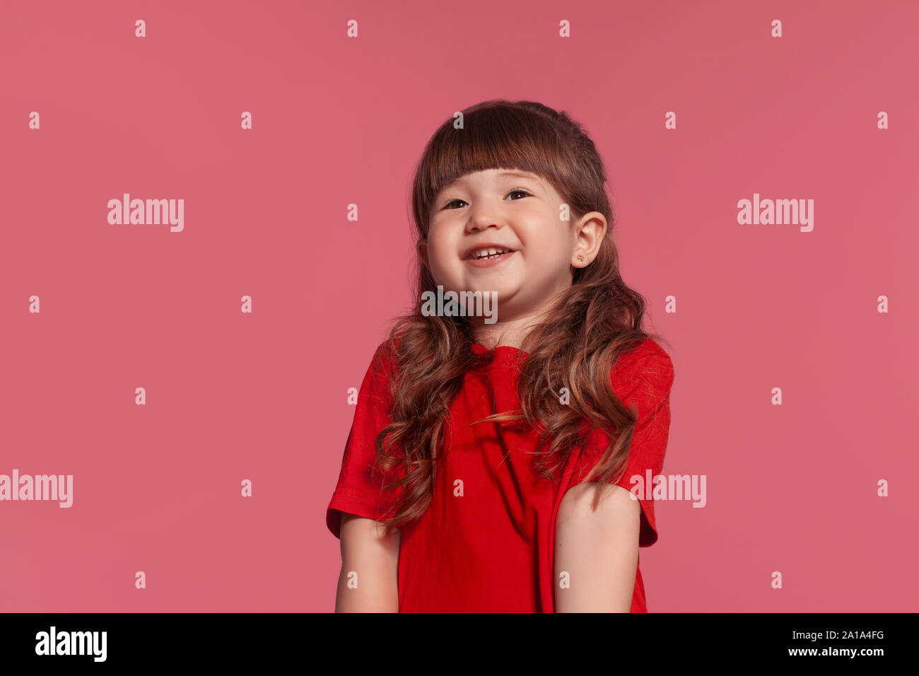 Hermosa niña de dos años con camiseta roja sonriendo aislado sobre