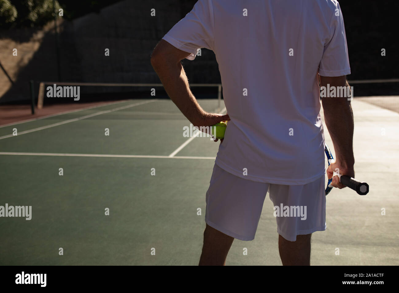 Hombre jugando al tenis en un día soleado Foto de stock