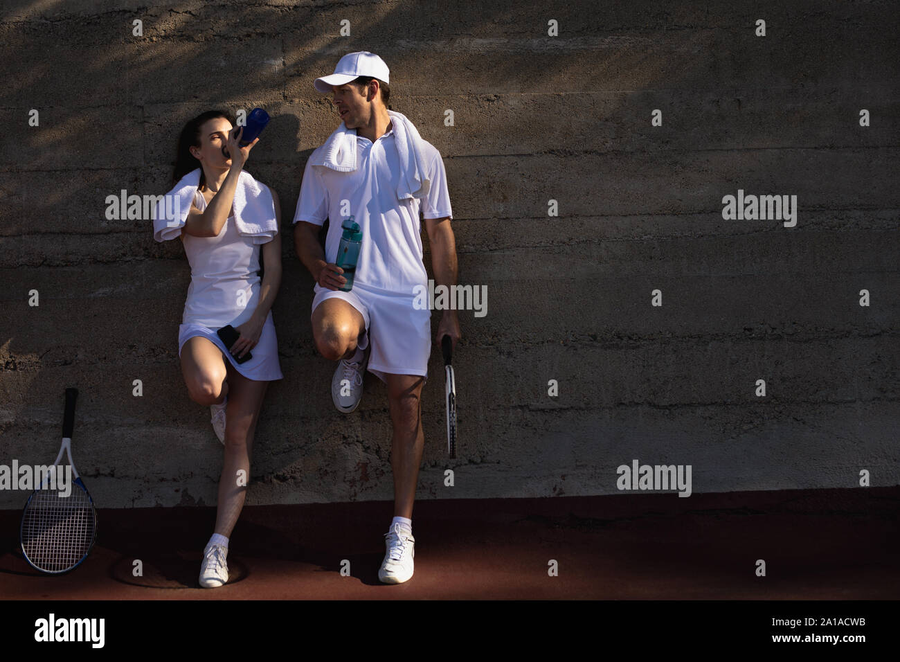 Mujer y hombre, tomando un descanso durante un partido de tenis Foto de stock