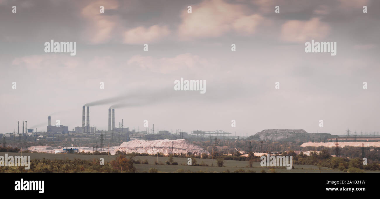 Vista panorámica de la fábrica con el hábito de fumar chimeneas y el cielo con nubes en Ucrania Foto de stock