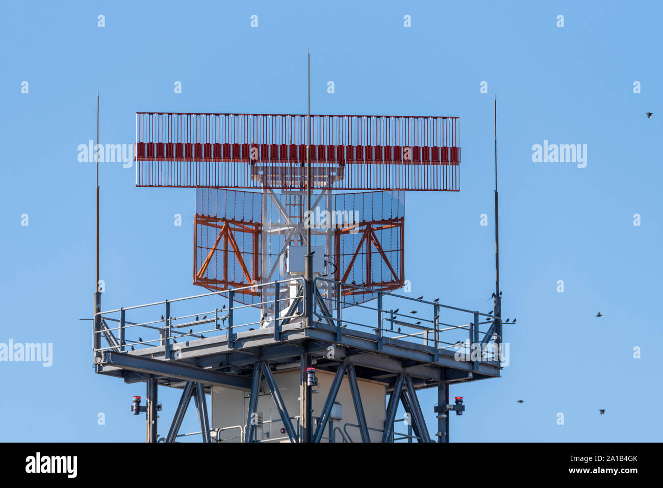 Una antena de radar en funcionamiento en el aeropuerto de Heathrow, Londres, Reino Unido. Las aves en la estructura. Espacio para copiar Foto de stock