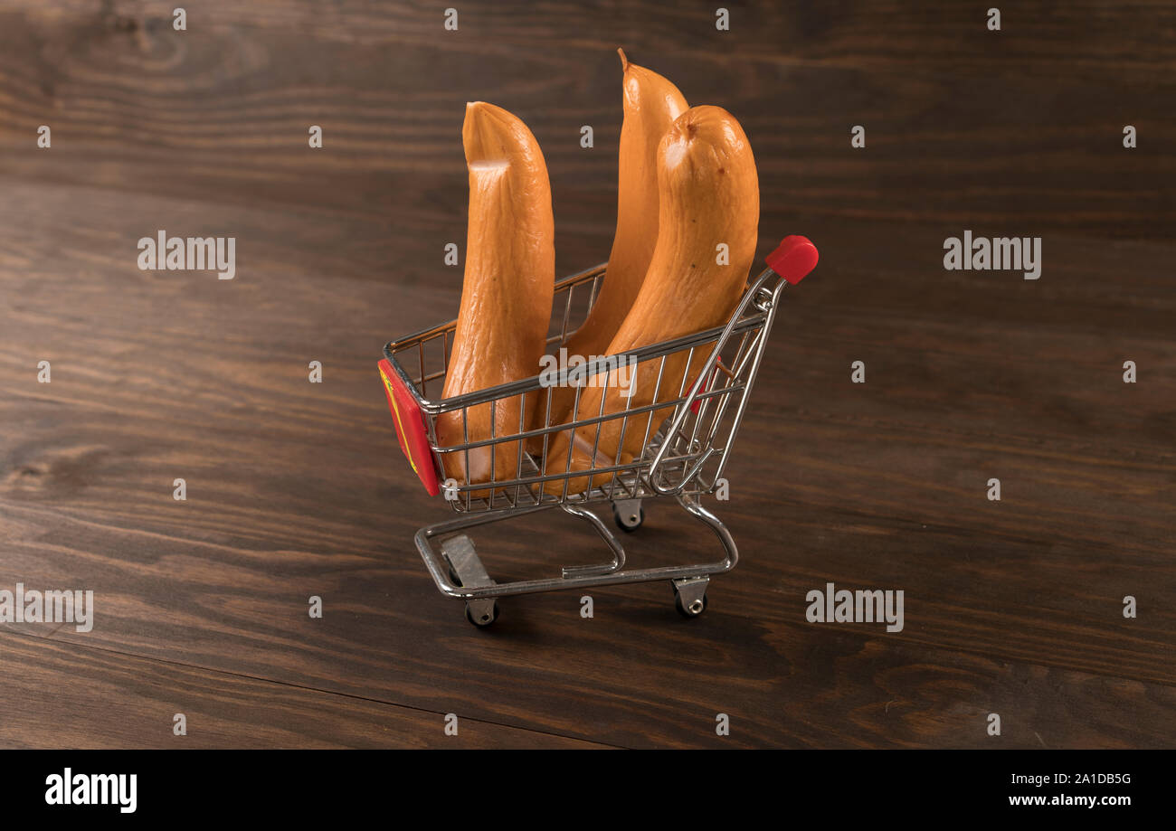 Las salchichas en el supermercado carro con fondo de madera Foto de stock