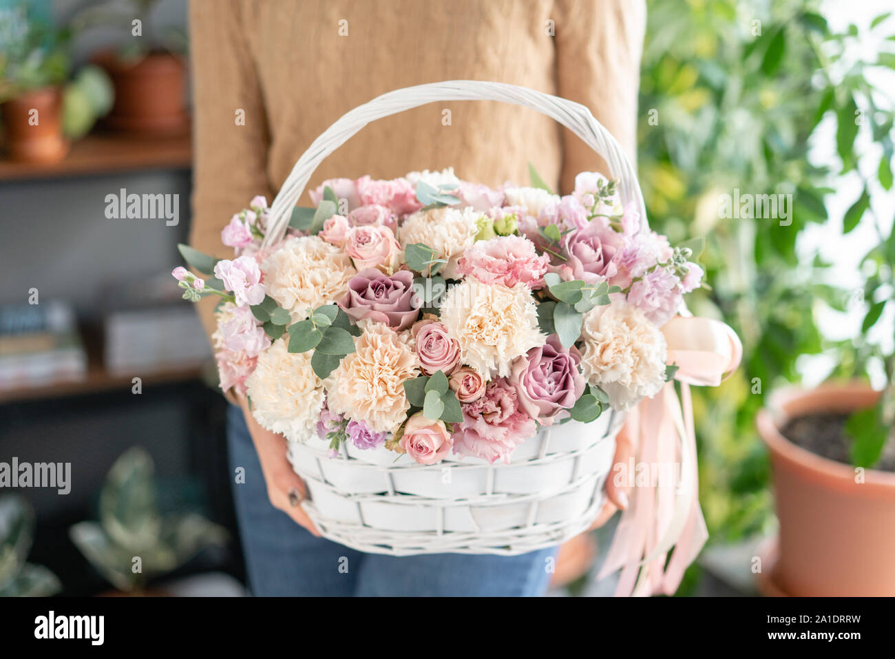 Arreglo floral en canasta de mimbre. Precioso ramo de flores variadas en la  mujer la mano. Tienda Concepto floral . Bouquet fresco guapo. Entrega de  flores Fotografía de stock - Alamy