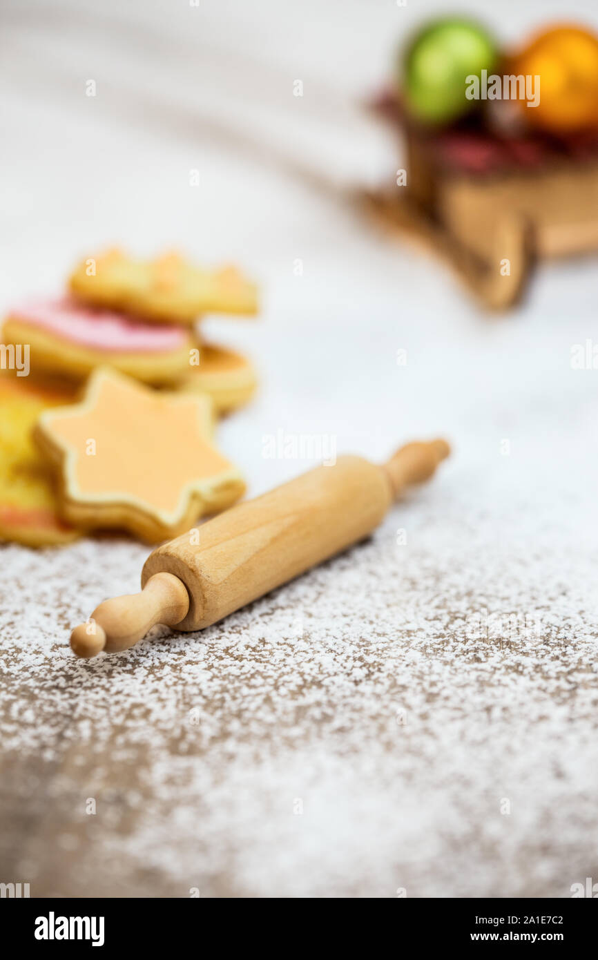 Galletas caseras, pasta de rollo y pizarra con bolas de navidad en azúcar glas, tarjeta de felicitación de temporada Foto de stock