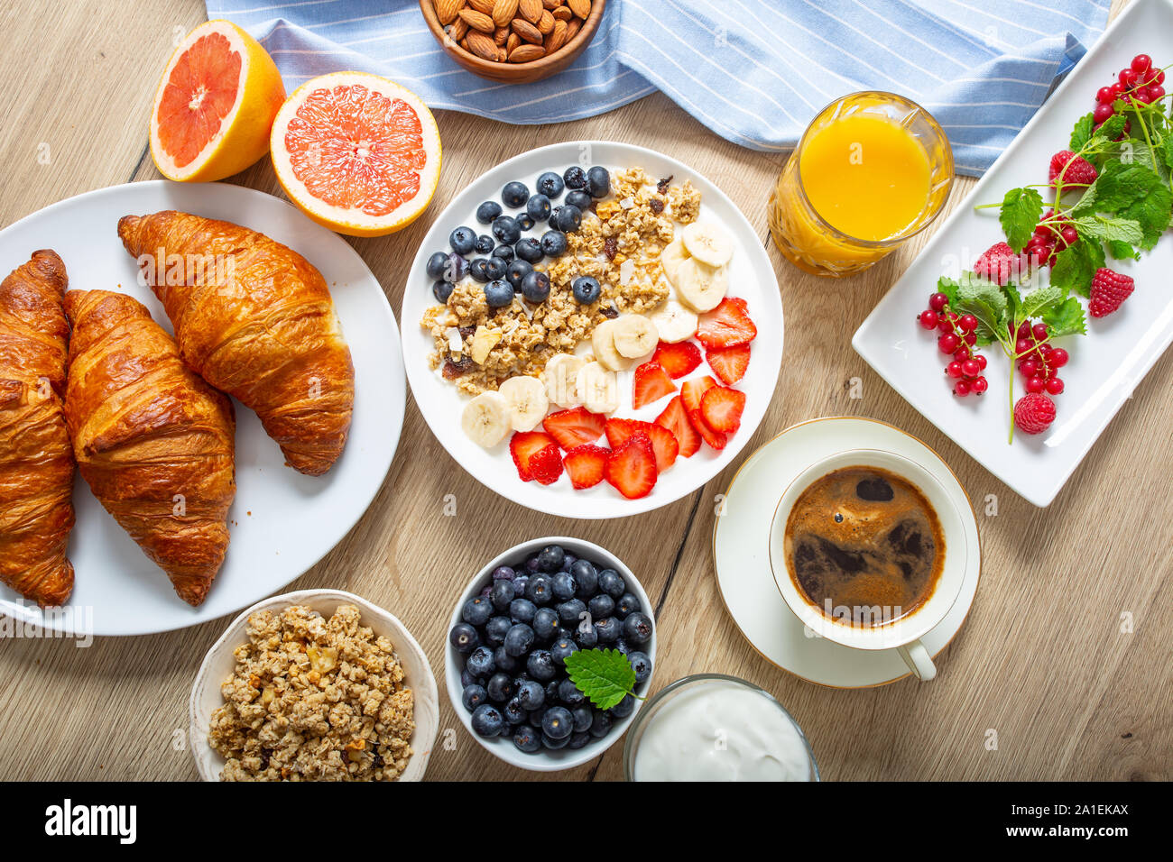 Desayuno saludable servido con placa de yogur con muesli arándanos fresas y plátano. Foto de stock