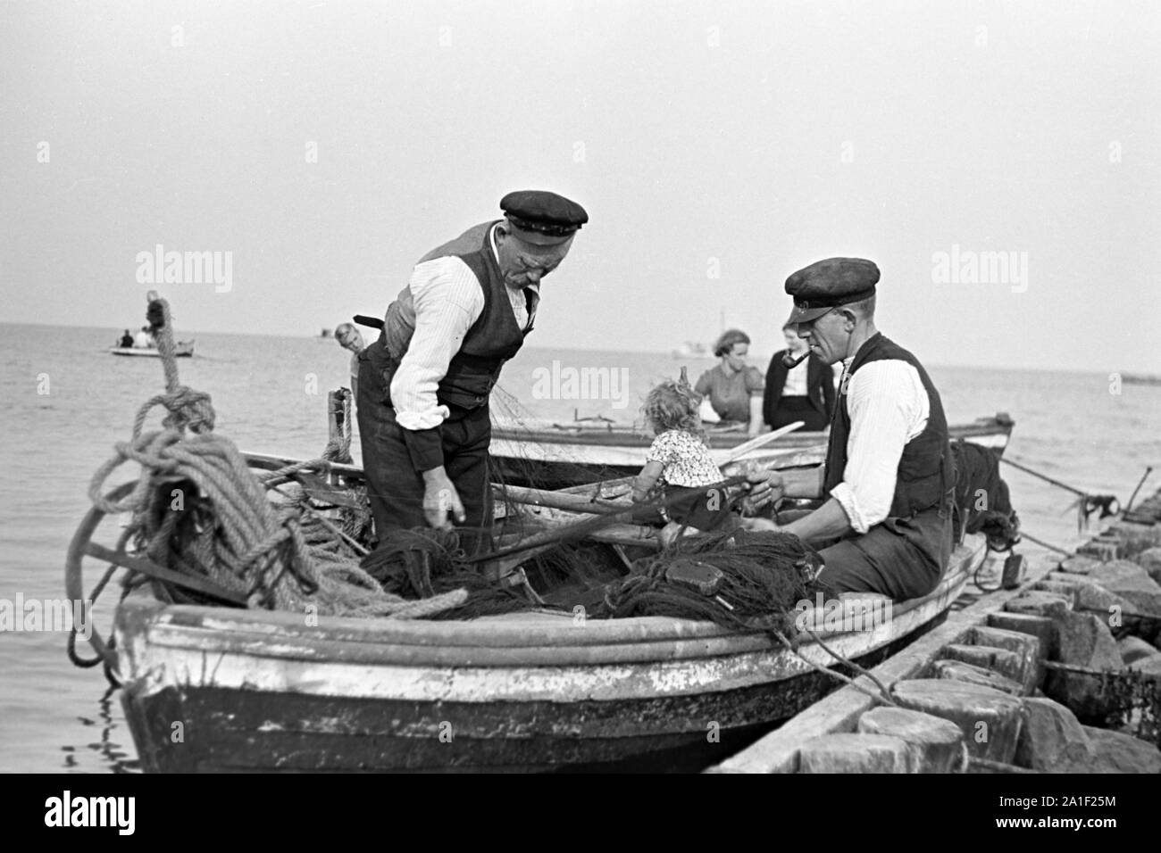 Fischer sortieren ihre Netze bevor sie sie zum Fischfang ins Meer auswerfen, Deutschland 1939. Los pescadores assorting sus redes antes de depositarlos en el agua, Alemania 1939. Foto de stock