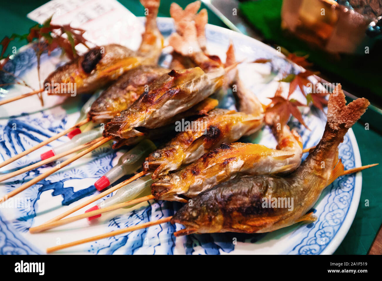 Parrillada de pescados en palos como la comida en la calle al mercado de Nishiki, Kyoto Foto de stock
