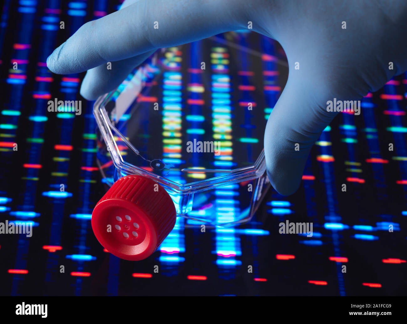 La investigación genética, matraz conteniendo células con el perfil de ADN detrás. Foto de stock