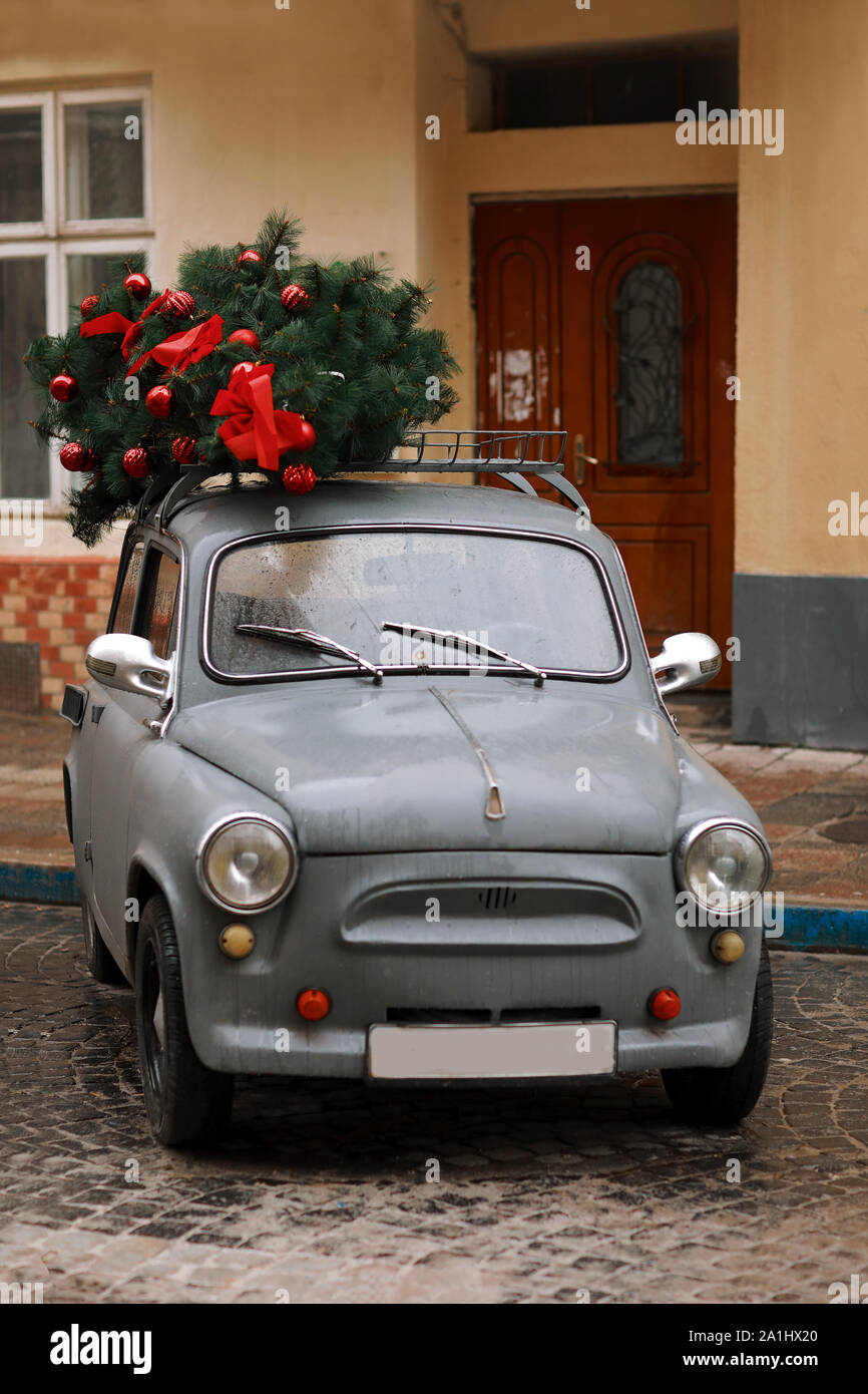 Retro coche gris con árbol de navidad decorado con capas rojas y mariposas.  Vista de un coche rojo retro con árbol de Navidad. El invierno. Navidad. NA  Fotografía de stock - Alamy