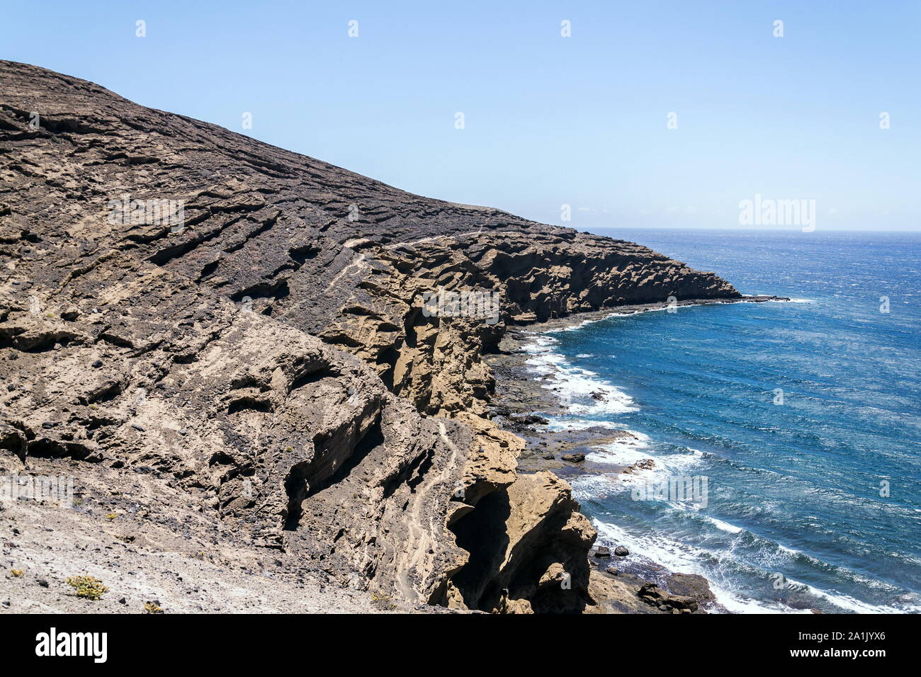 Olas rompiendo en espectaculares acantilados en la costa sur, Montana Montaña Pelada, Tenerife, Islas Canarias, España, un día soleado de verano Foto de stock
