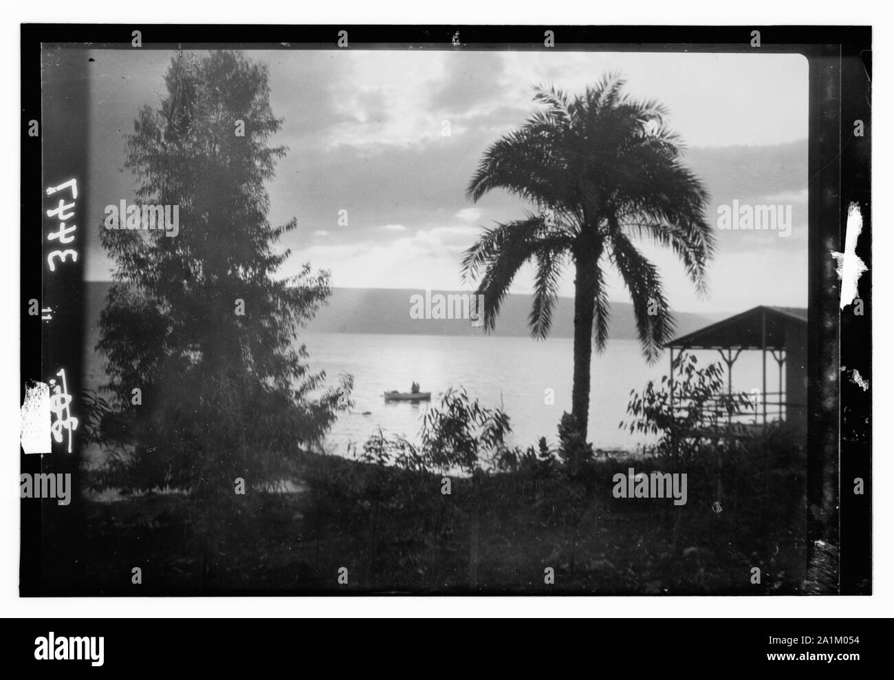 Vistas del norte. El lago de Galilea. Amanecer de Tiberias. Pintoresco con palmera y barco Foto de stock