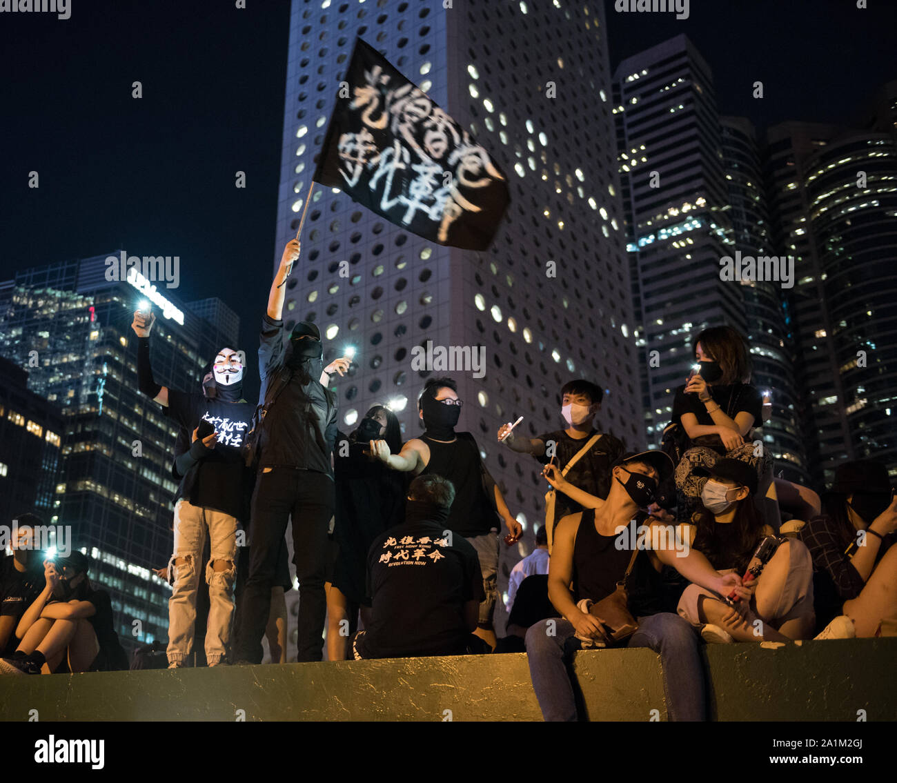 Un manifestante olas un banner y brillar la luz durante la demostración.Miles de manifestantes antigubernamentales celebraron una manifestación contra la brutalidad policial y los supuestos casos de palizas y la denegación de los derechos jurídicos que se produjeron en San Uk Ling centro de detención. Los manifestantes cantaron canciones, coreaban consignas y enarbolaron varios banners mientras escuchaban a los oradores. Los manifestantes continúan luchando por sus 5 demandas contra la policía y el gobierno. Foto de stock